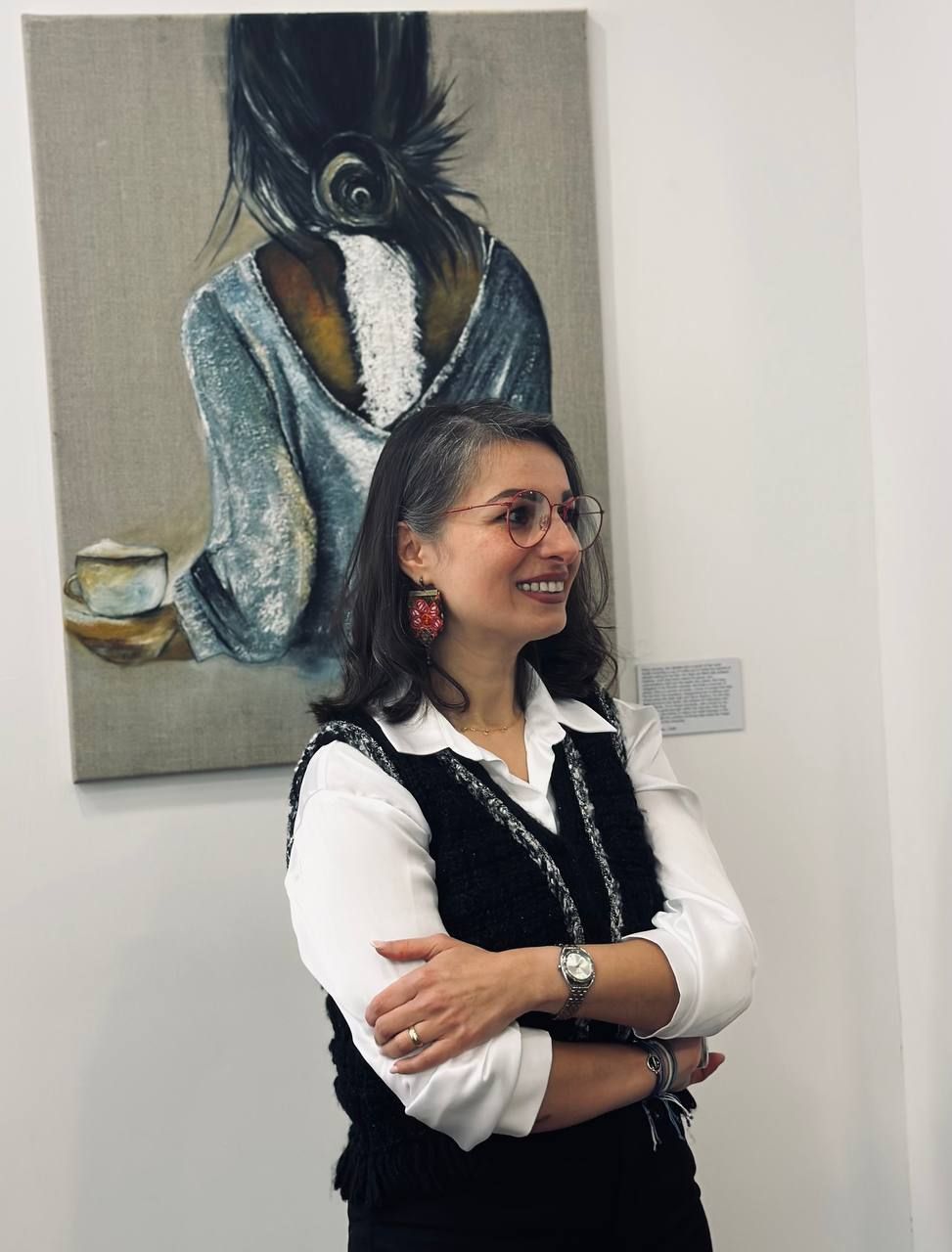 Saeideh standing in front of a painting